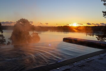 Solnedgång över infinitypoolen i skärgården. Havsutsikt.