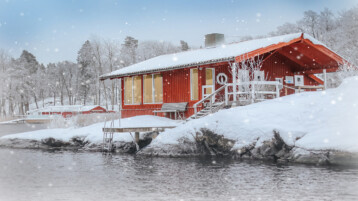 Vedeldad bastu i skärgården. Snön faller i skärgården.