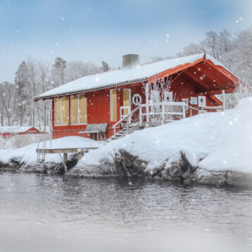Vedeldad bastu i skärgården. Snön faller i skärgården.